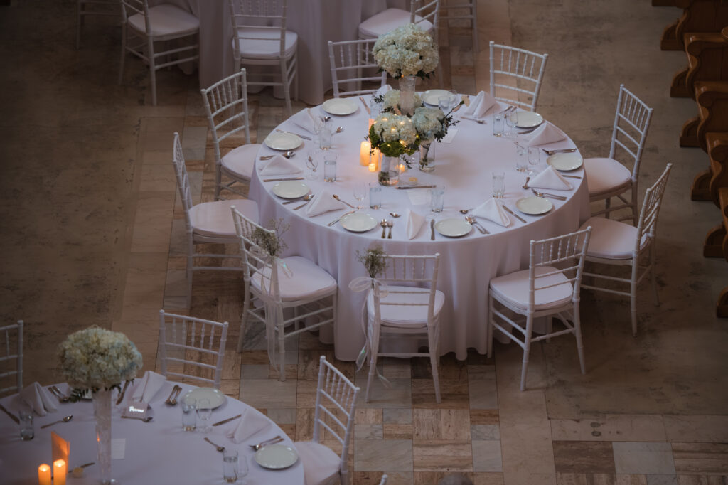 Chapelle de l'Abbaye d'Oka avec tables rondes et décor sobre pour cérémonie de mariage - BlanchePhotographe