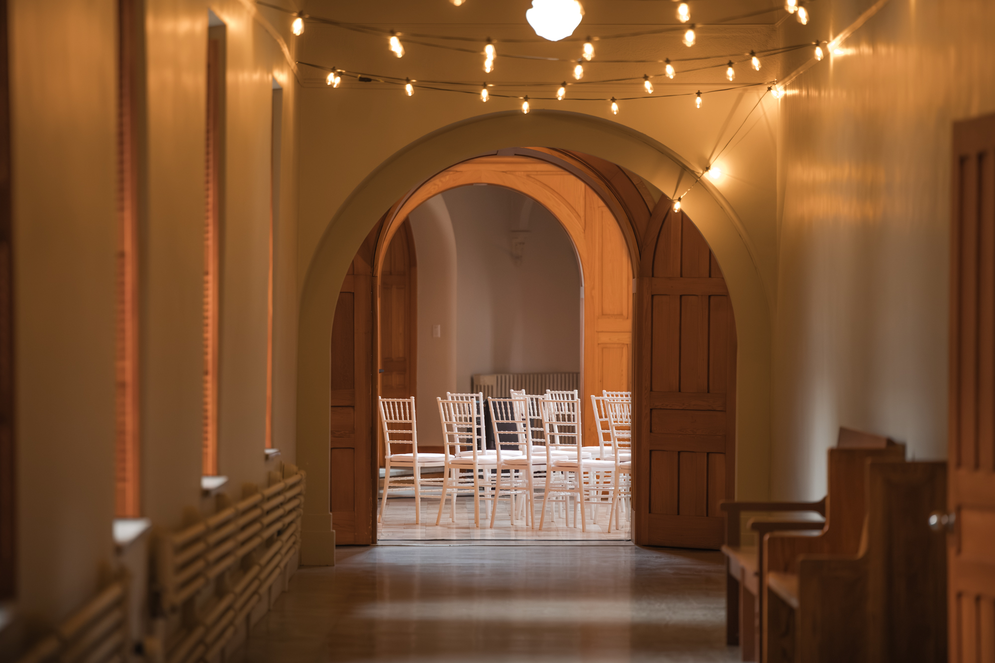 Couloir de l'Abbaye d'Oka avec au fond les chaises pour la cérémonie de mariage