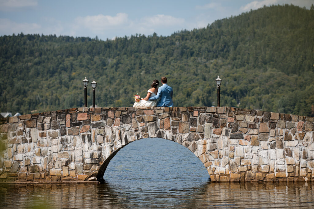 Mariage intime et photo de couple sur pont de pierres au bord d'un lac.